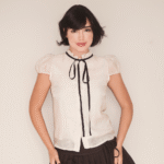 Blusa branca com laço preto e saia plissada Soiko